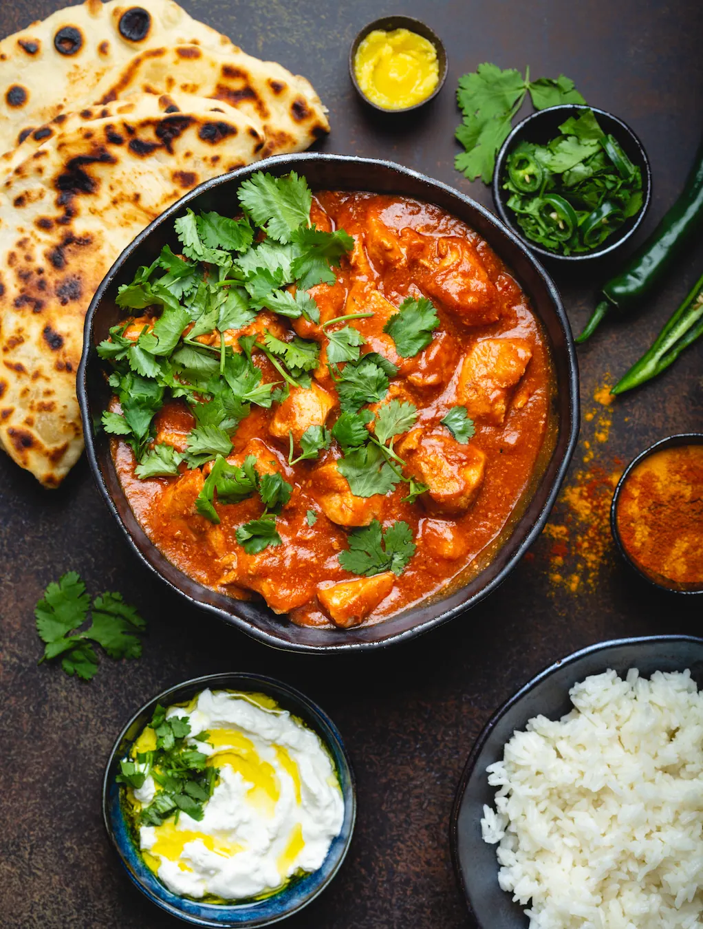 Chicken tikka masala topped with fresh coriander, served with naan and yoghurt
